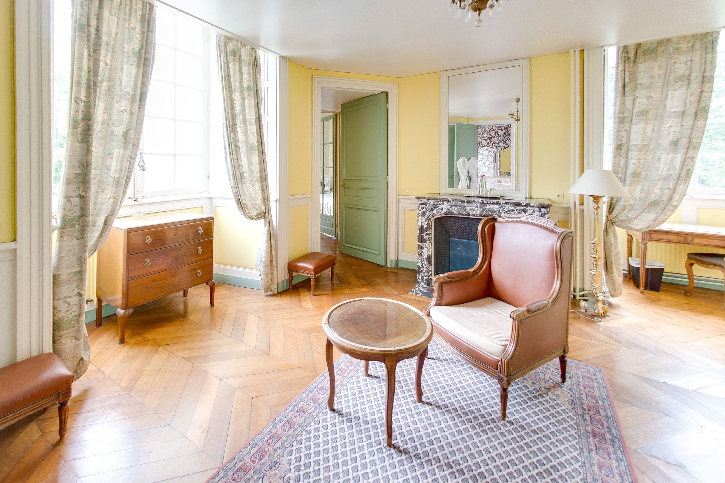 A room with a fireplace, a sofa, a wooden bench, and a small table.
