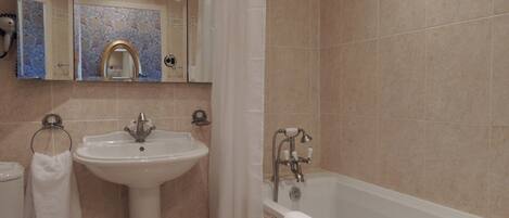 A bathroom with a sink, toilet, and bathtub.
