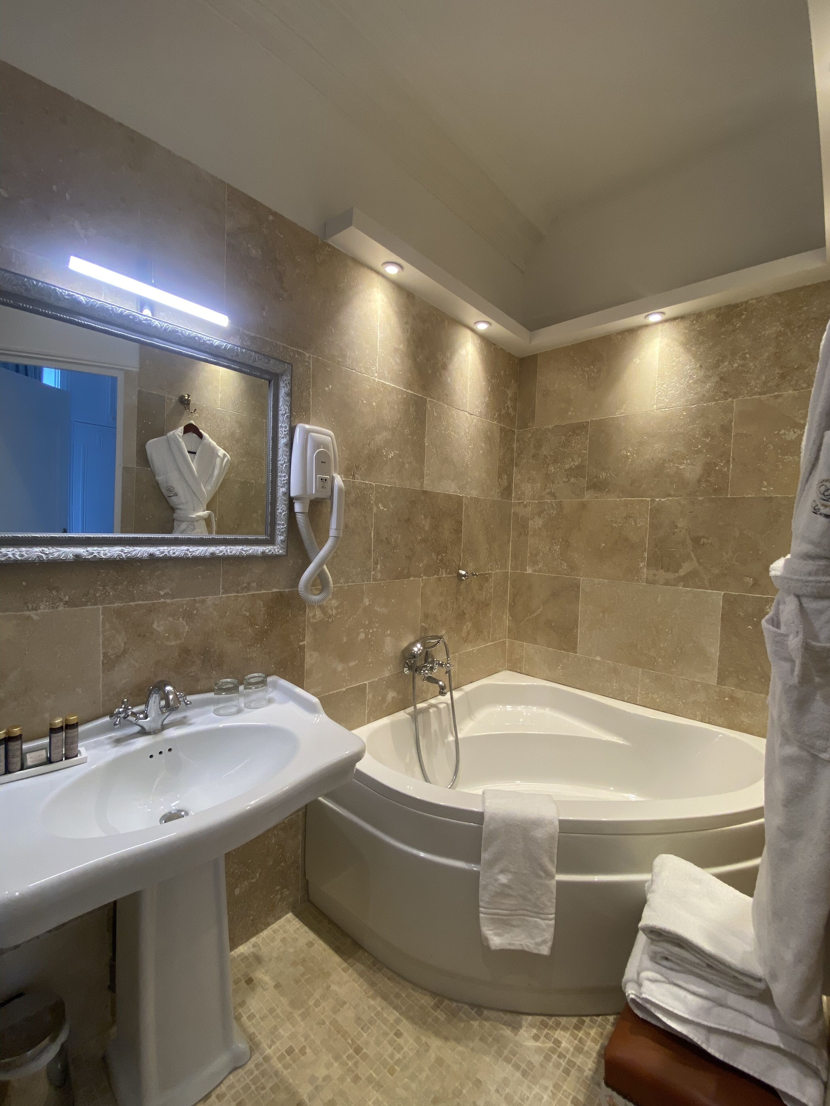 Un baño con bañera, lavamanos y espejo.