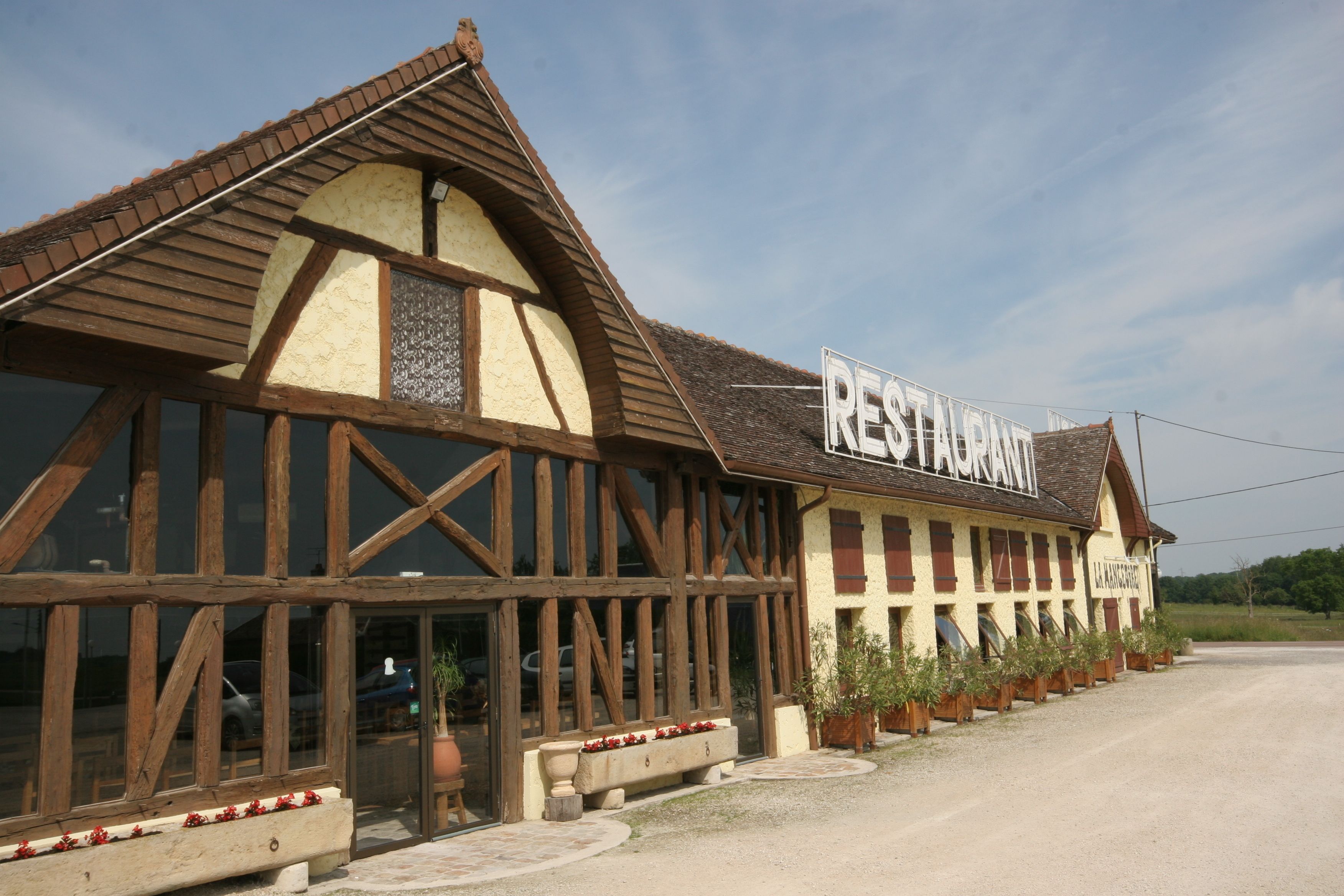 Un edificio tradicional con entramado de madera, con un letrero que dice "RESTAURANT" y una entrada visible.