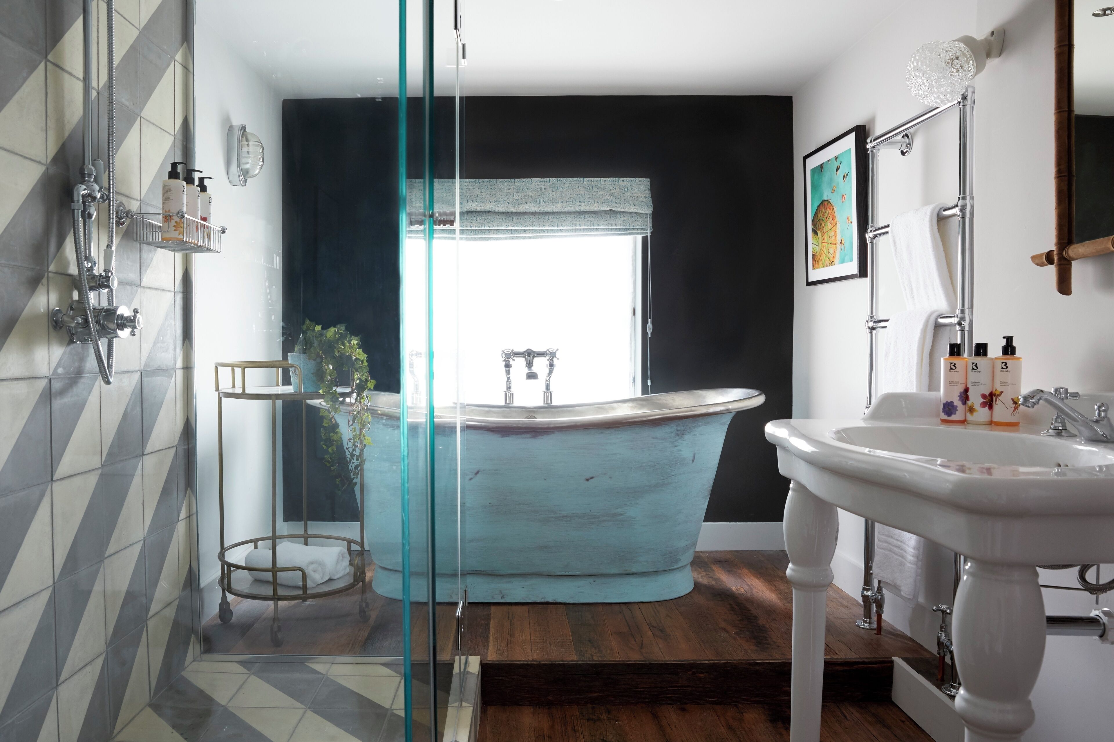 A bathroom with a bathtub, a sink, and a shower area.