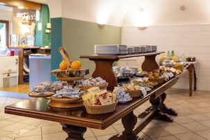 A buffet table with various food items and condiments.