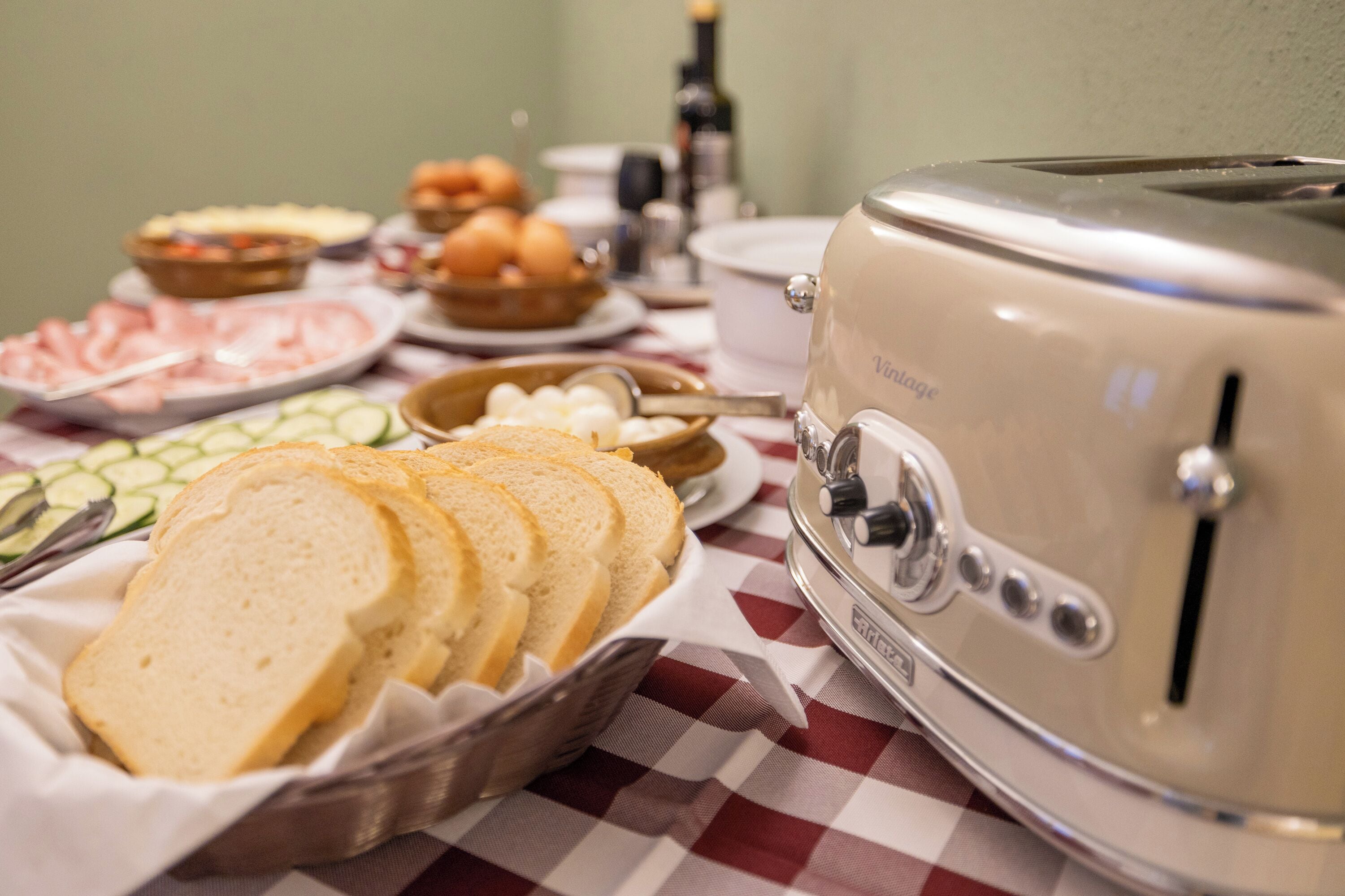 A table with various food items including bread, eggs, and vegetables, and a vintage toaster.