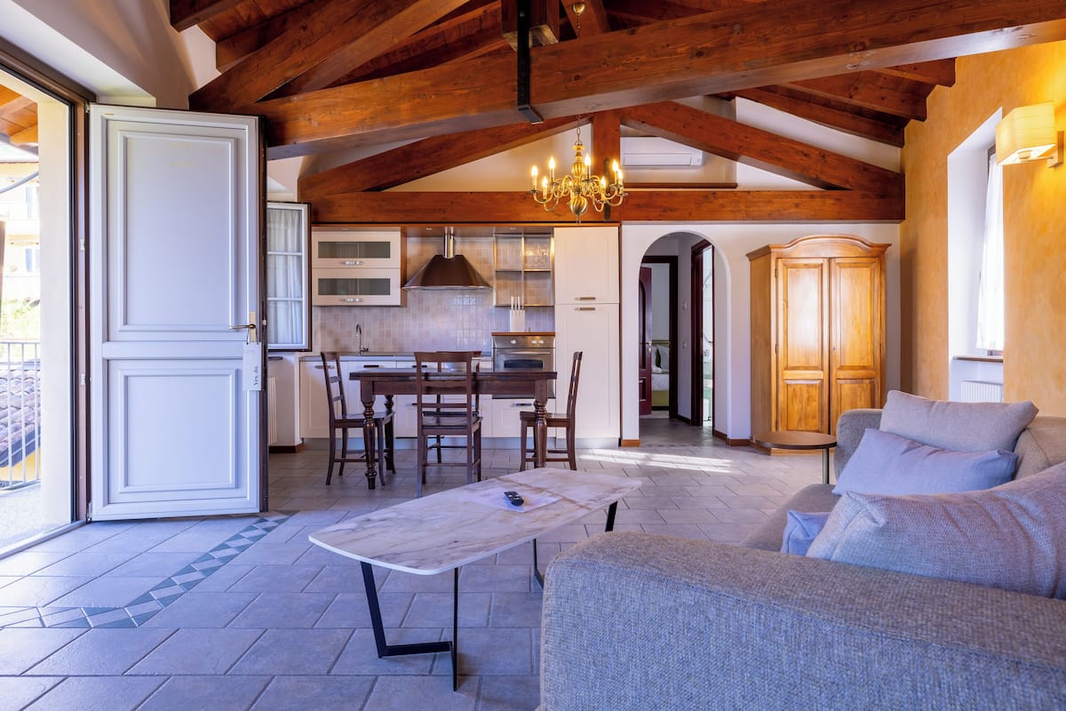 A spacious living area with a wooden ceiling, a dining table, and a sofa.