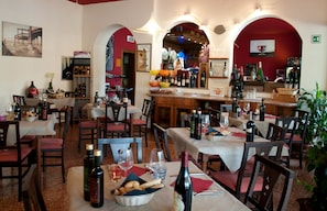 Un restaurant doté de nombreuses tables et chaises, de bouteilles de vin et d’un bar.