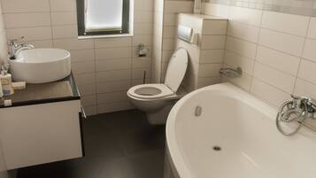 Een badkamer met een wastafel, toilet en bad.