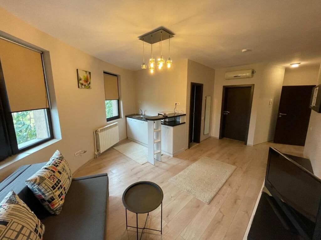 Un espace de vie moderne comprenant une cuisine, un coin repas et un espace détente avec un canapé et une petite table.
