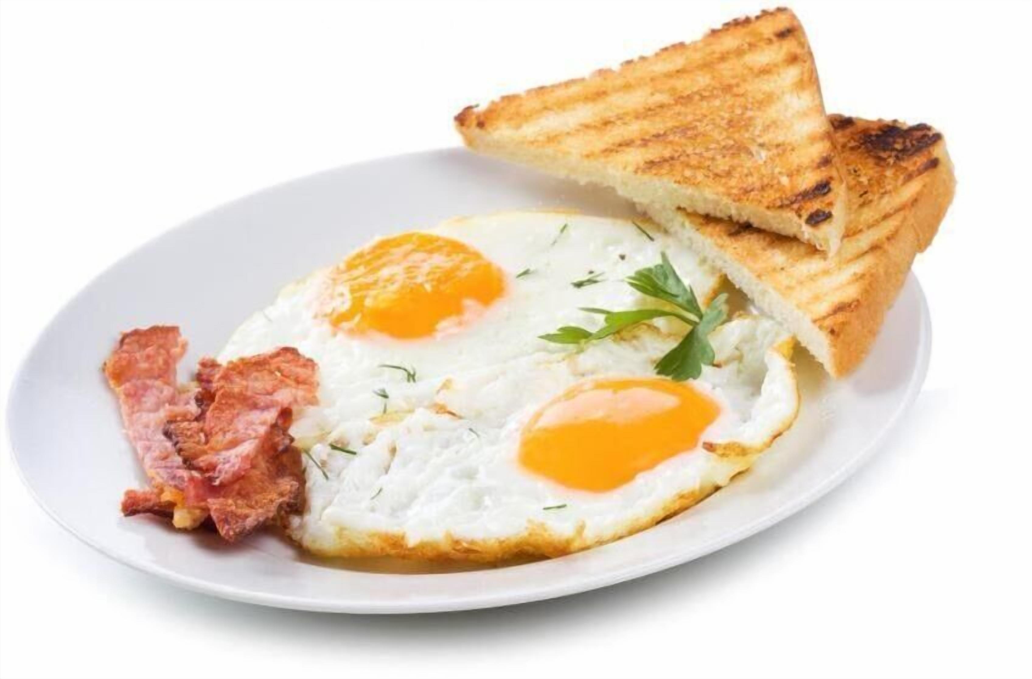 Une assiette avec deux œufs au plat, une tranche de pain grillé et une tranche de bacon.