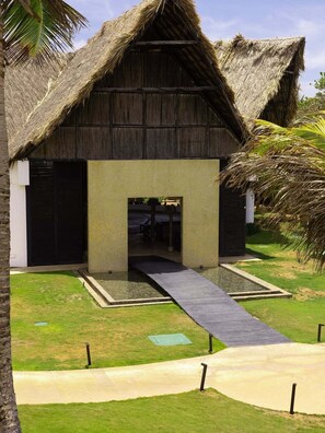 A building with a thatched roof and a central entrance.