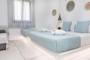 A modern bedroom with two beds, a bedside table, a lamp, and a window with sheer curtains. - Korali Palace (Naxos)
