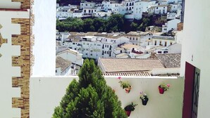 A view of a town with white buildings and a green hill in the background. - Hotel Villa de Setenil (Setenil de las Bodegas)