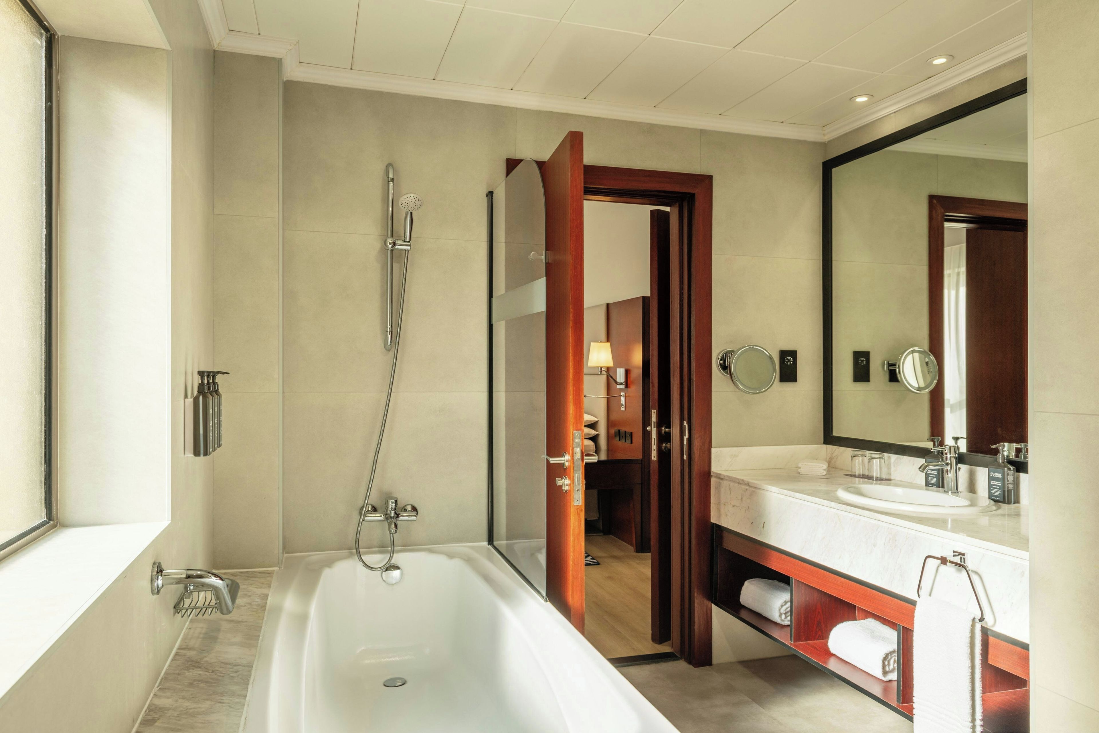 A modern bathroom with a bathtub, a shower, and a vanity with a mirror.