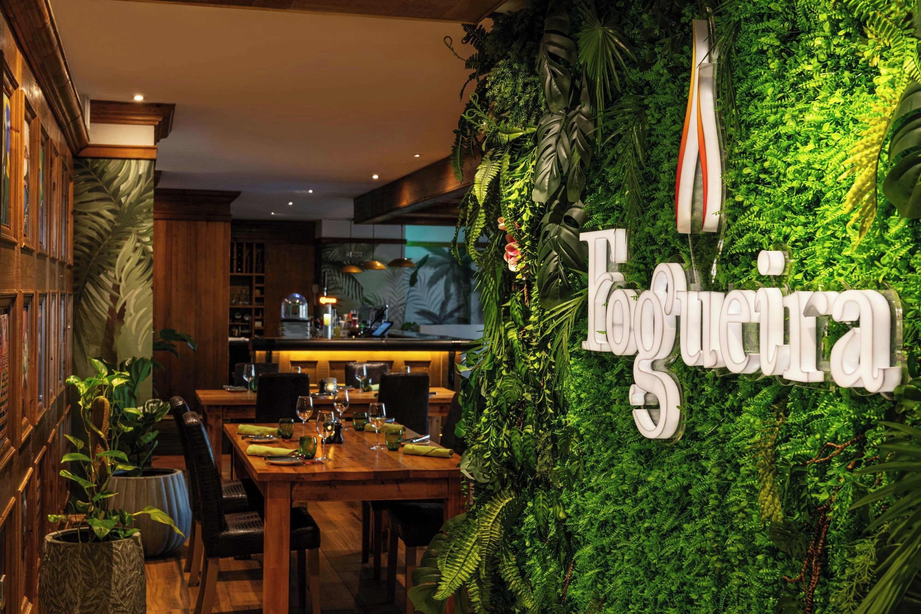 A restaurant with a green wall and the name 'Logueira' in white letters.