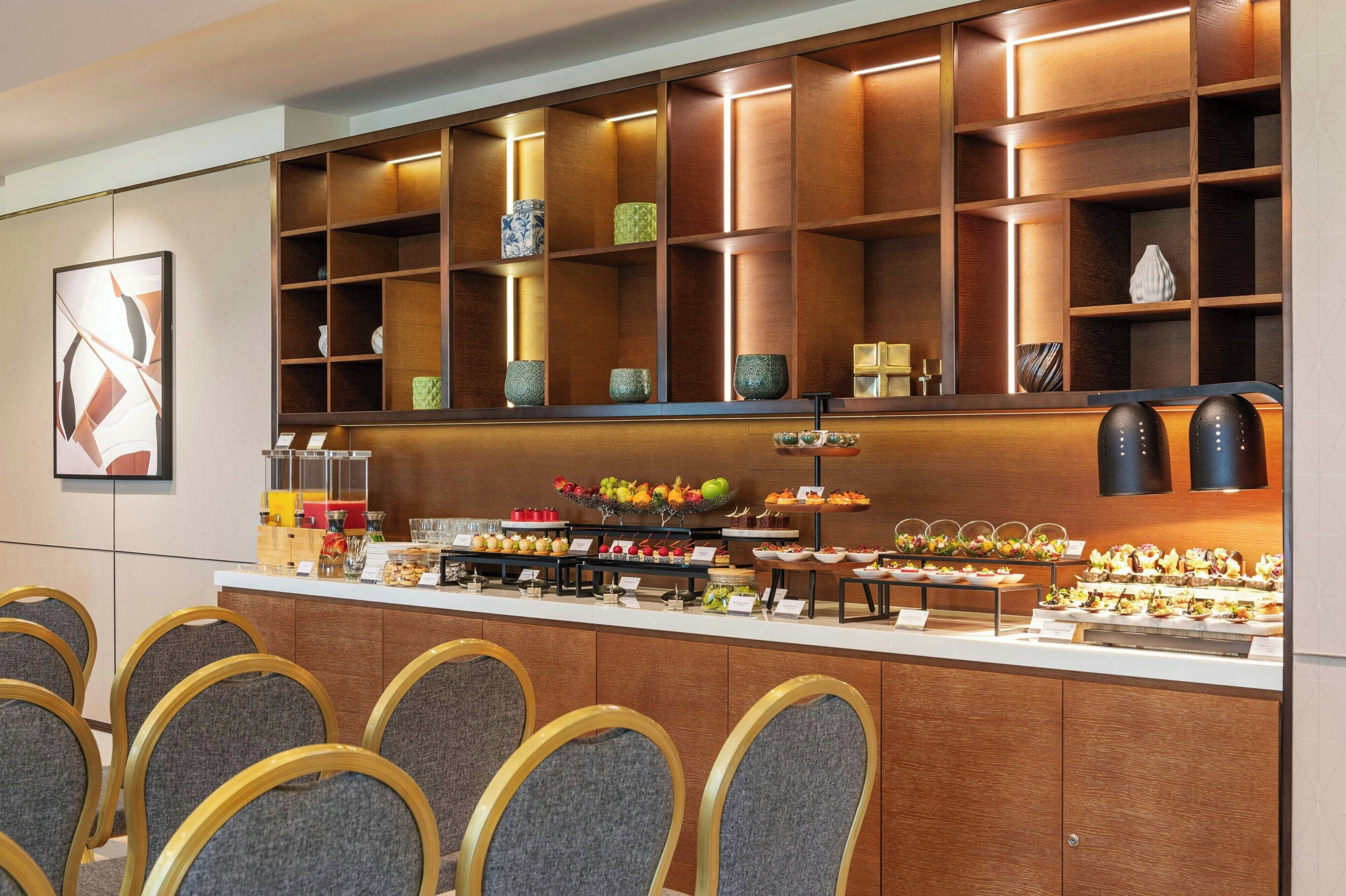 Uma área de buffet com diversos tipos de comida e uma exposição de vasos decorativos.