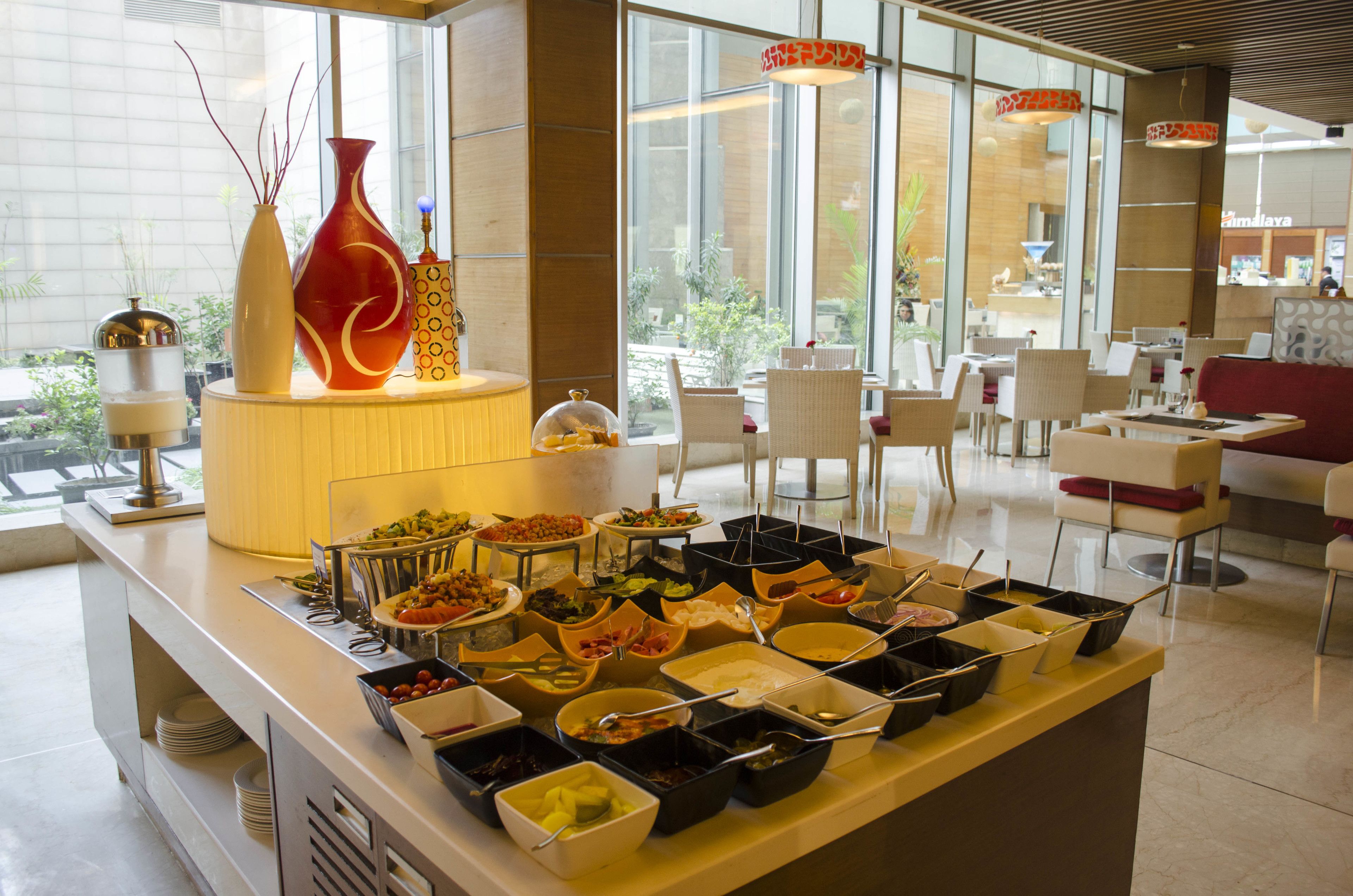 A buffet with various food items and a seating area with chairs and tables.