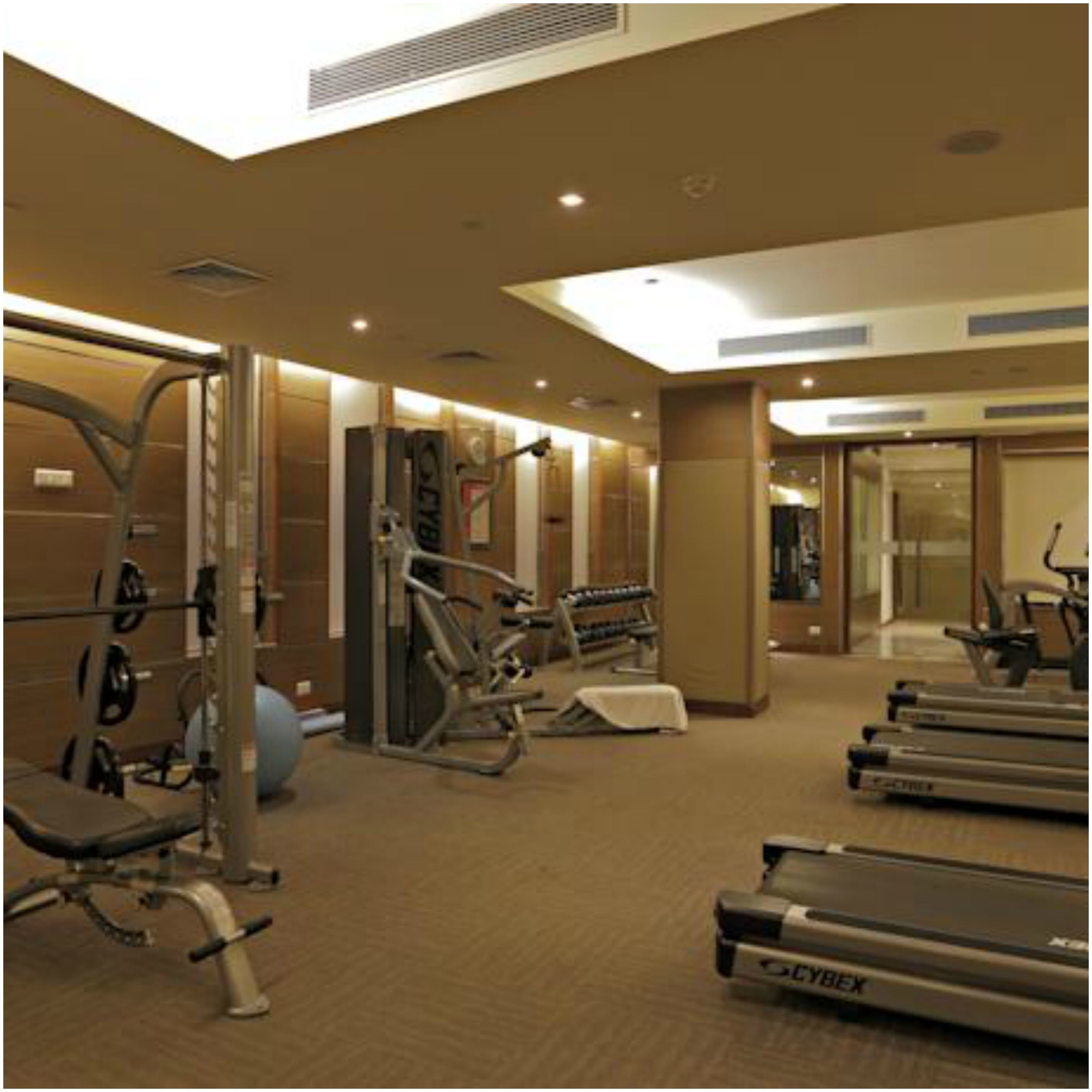 A gym with cardio equipment, weight machines, and a treadmill.