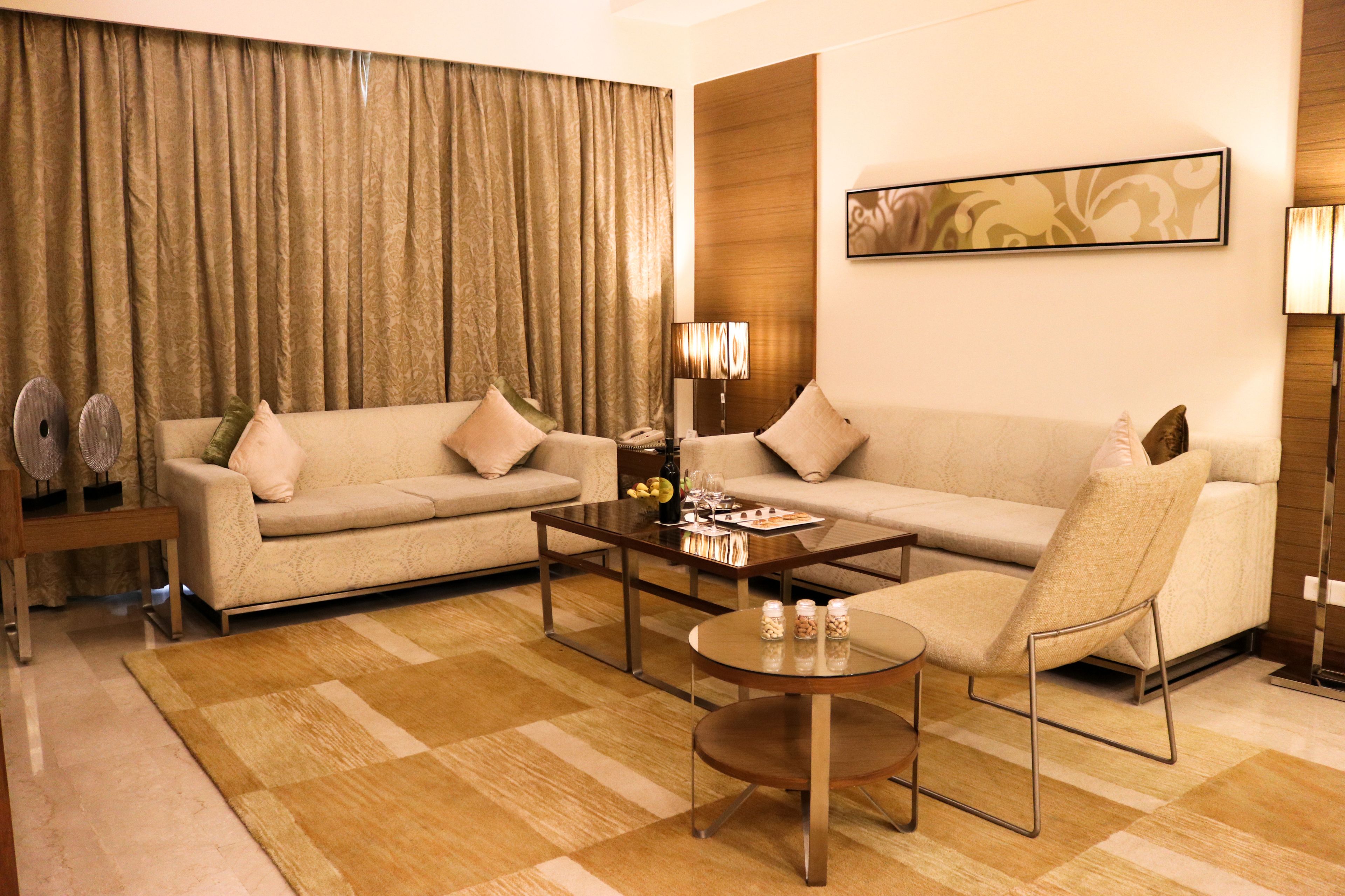 Una sala de estar moderna con sofá, sillón, mesa de centro y lámpara.