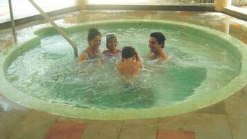 A circular indoor pool with four people swimming.