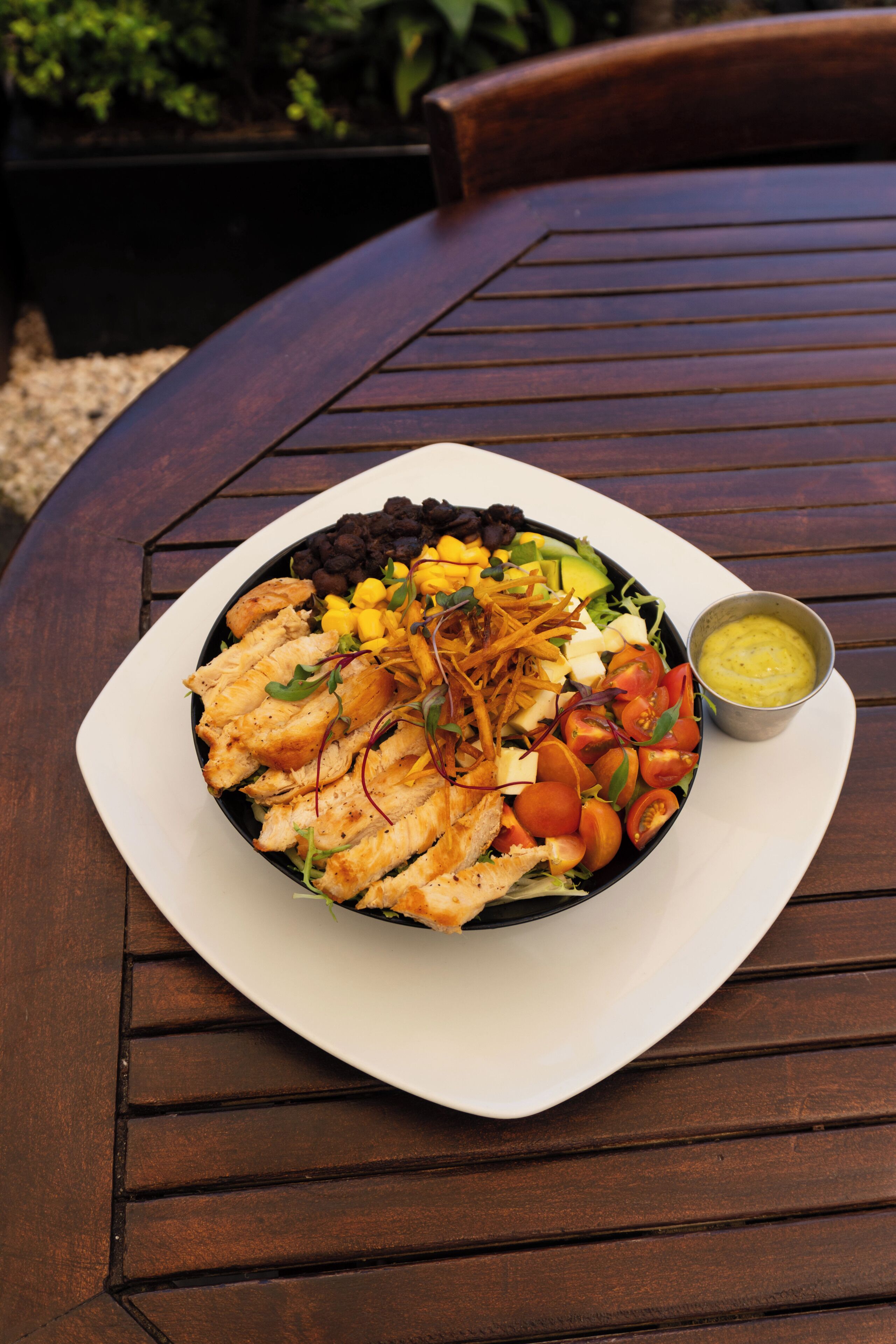 A plate of food on a round wooden table.