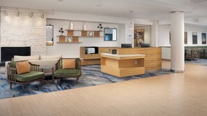 A modern lobby with a reception desk, seating area, and a stone wall. - Fairfield Inn & Suites Baltimore BWI Airport (Linthicum Heights)