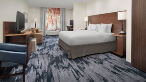 A hotel room with a large bed, a desk with a computer, a chair, a TV, and a window with curtains. - Fairfield Inn & Suites Baltimore BWI Airport (Linthicum Heights)