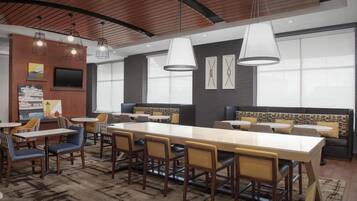 Un espace de restauration moderne doté d’une longue table conviviale, de plusieurs options d’assises et d’un éclairage suspendu.