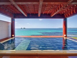 Uma piscina infinita com vista para o oceano e ilhas.