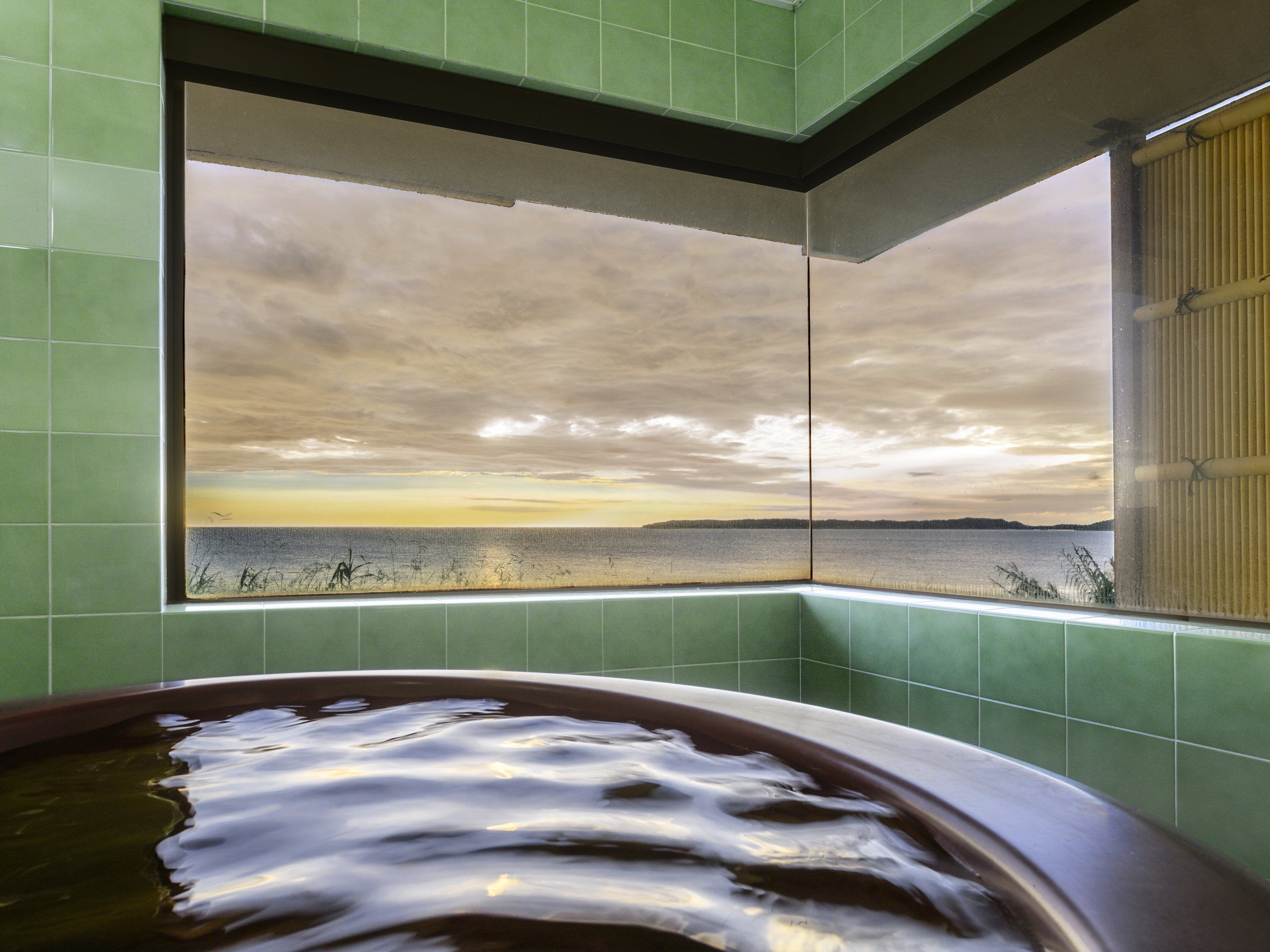 Una bañera con vista al agua y un cielo nublado.