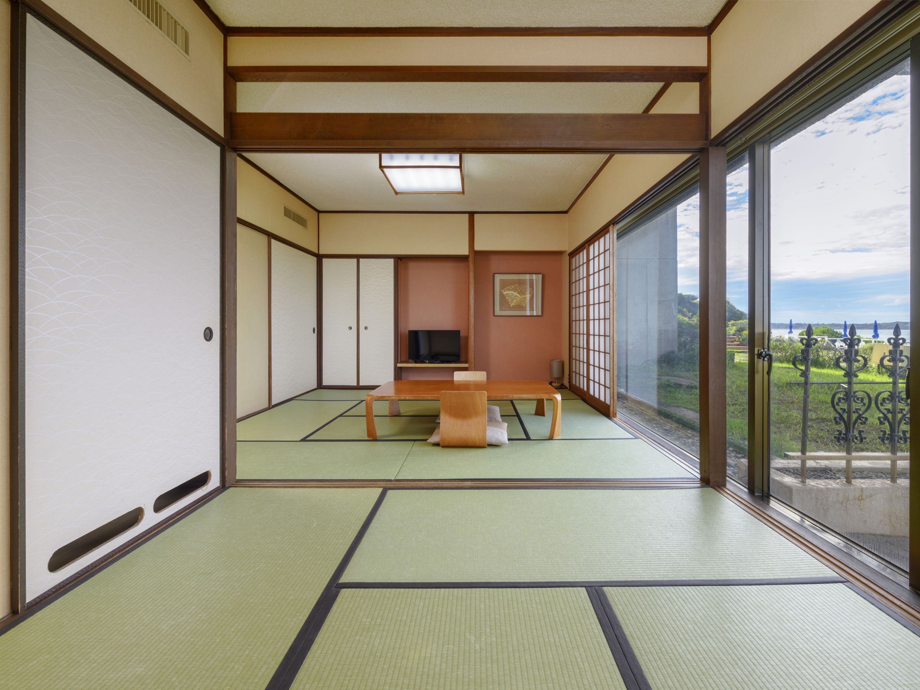 A traditional Japanese room with tatami flooring, a low table, and sliding doors.