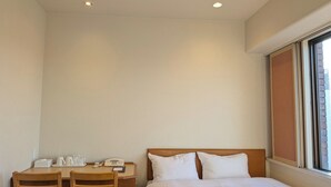 A hotel room with a bed, a desk with a telephone, and a window. - Smile Hotel Sugamo (Tokyo)