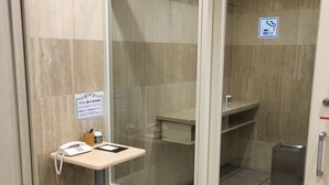A hotel reception area with a telephone, a small table, and a sign indicating a smoking area. - Smile Hotel Sugamo (Tokyo)
