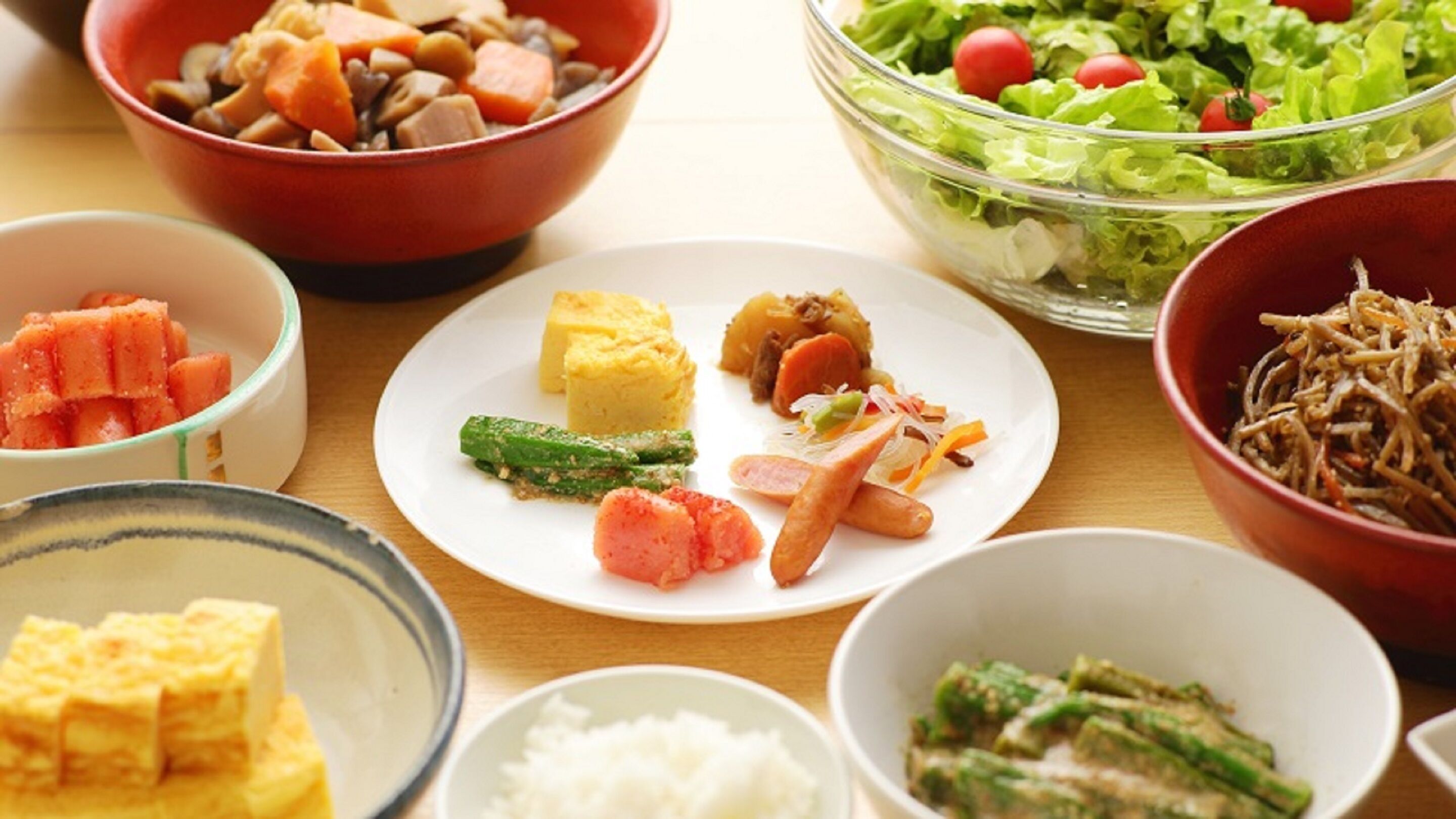 Una varietà di piatti, tra cui un'insalata, una zuppa e diversi piatti con cibi diversi.