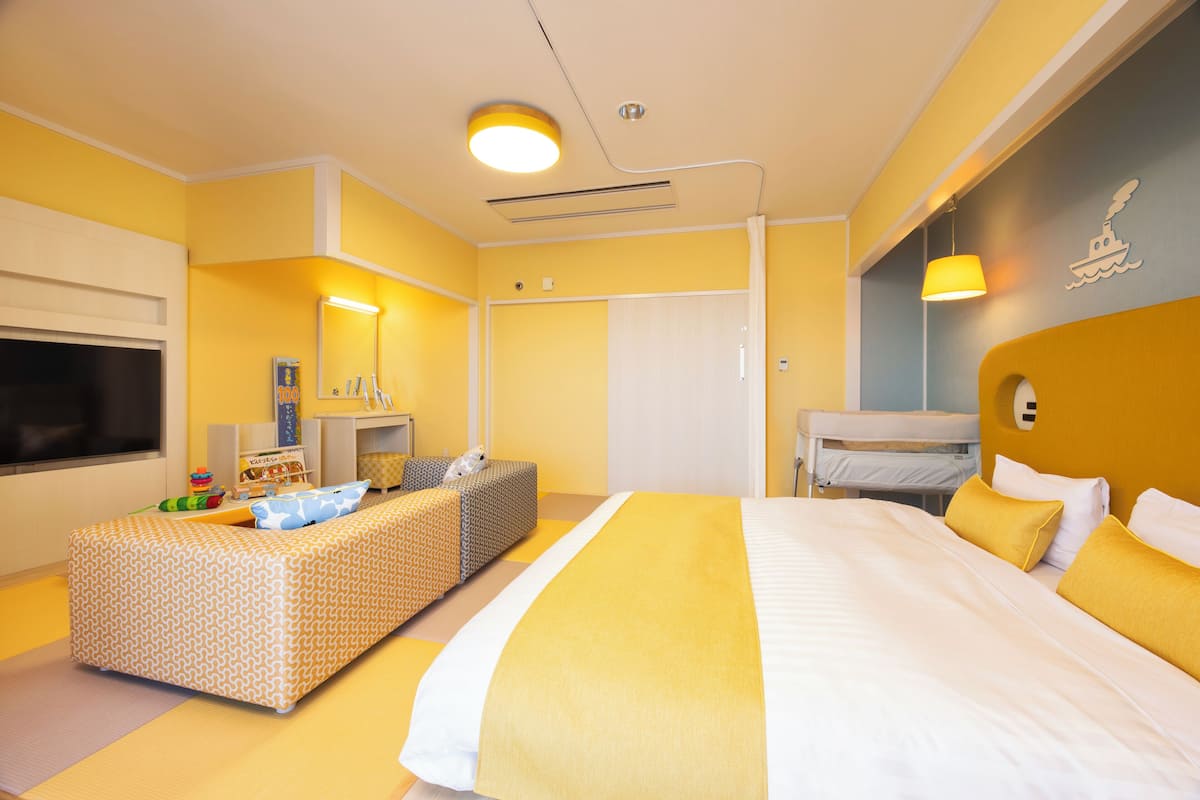 Een hotelkamer met een groot bed, een bank, een bureau en een televisie.