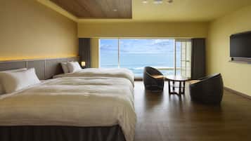 Habitación de hotel con una cama grande, una mesita, una silla y un televisor montado en la pared.