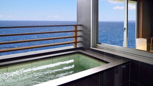 Ein Balkon mit Meerblick, einem gläsernen Whirlpool und einem Holgitter.