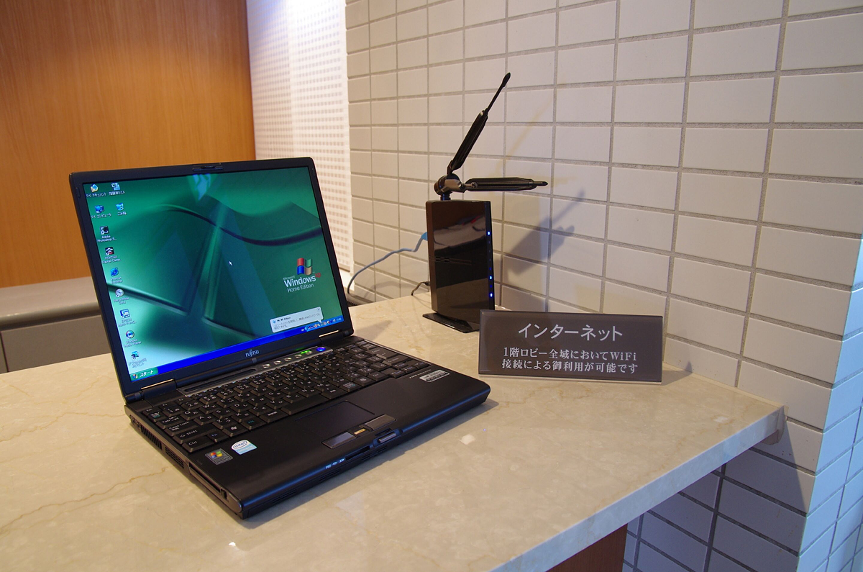 A laptop on a counter with a sign in a foreign language.
