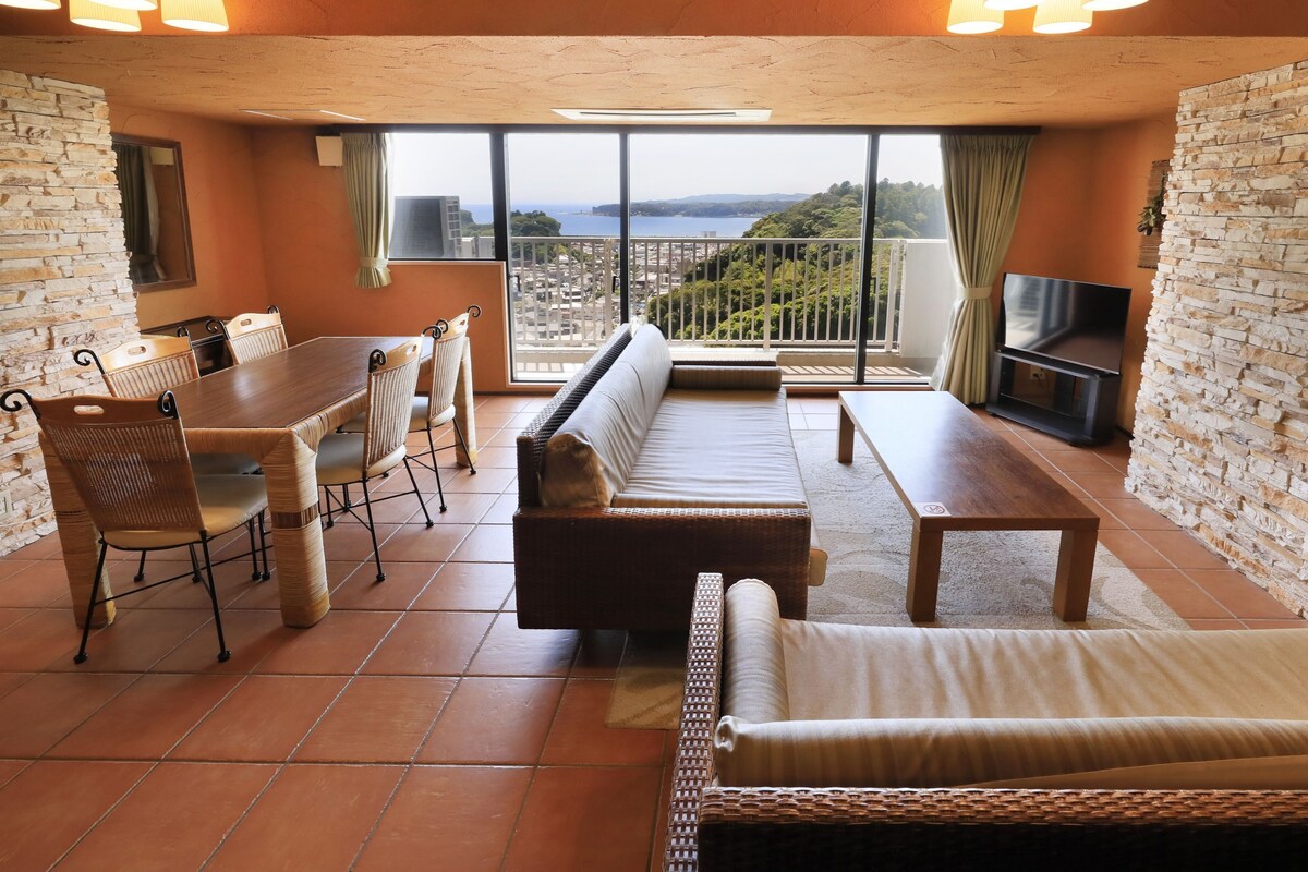 Une pièce spacieuse comprenant un coin repas, un canapé et un balcon avec vue.