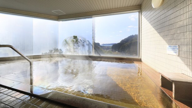 A hot spring bath with a view of a waterfall and mountains. - Katsuura Hilltop Hotel & Residence (Katsuura)