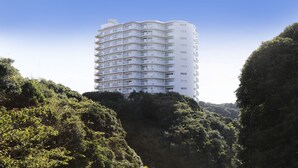 A multi-story hotel with balconies, surrounded by lush greenery. - Katsuura Hilltop Hotel & Residence (Katsuura)