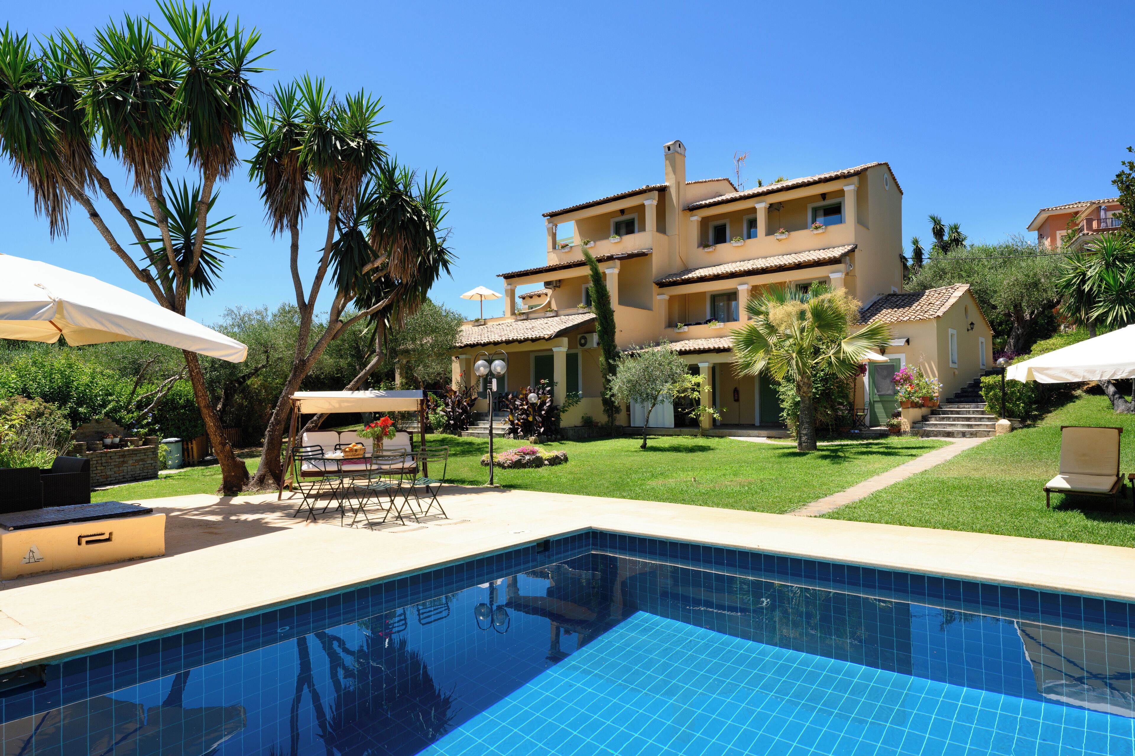 En säsongsöppen utomhuspool, parasoller och solstolar