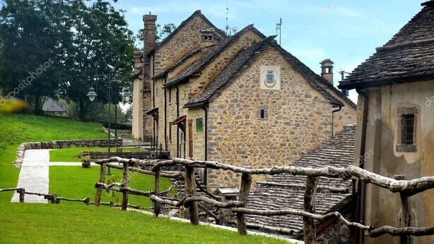 A stone building with a traditional design, a wooden fence, and a pathway leading to the entrance. - Albergo Canella (Fuipiano Valle Imagna)