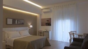 A hotel room with a bed, desk, chair, and a sofa. - B&B Medinblu Via Miraglia (Reggio Calabria)