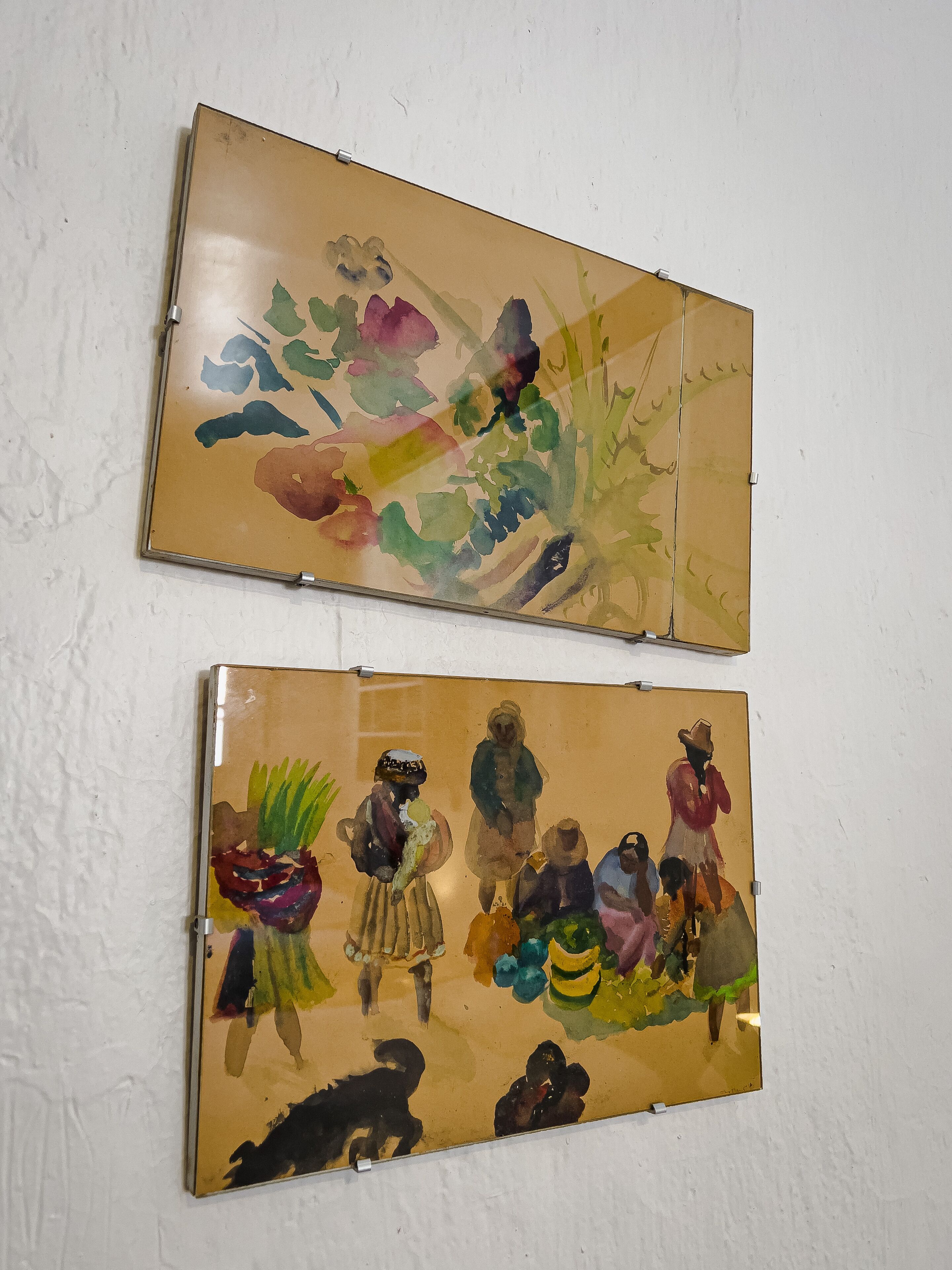 Two framed artworks on a white wall.