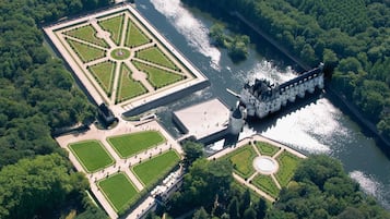 Luchtbeeld van een historisch park met een groot centraal plein, een kasteel en een rivier.
