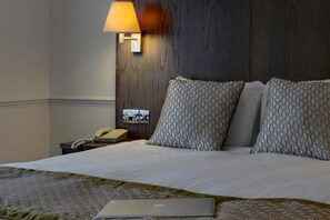 A hotel room with a bed, a bedside lamp, a telephone, and a laptop on the bed. - Best Western Ipswich Hotel (Ipswich)