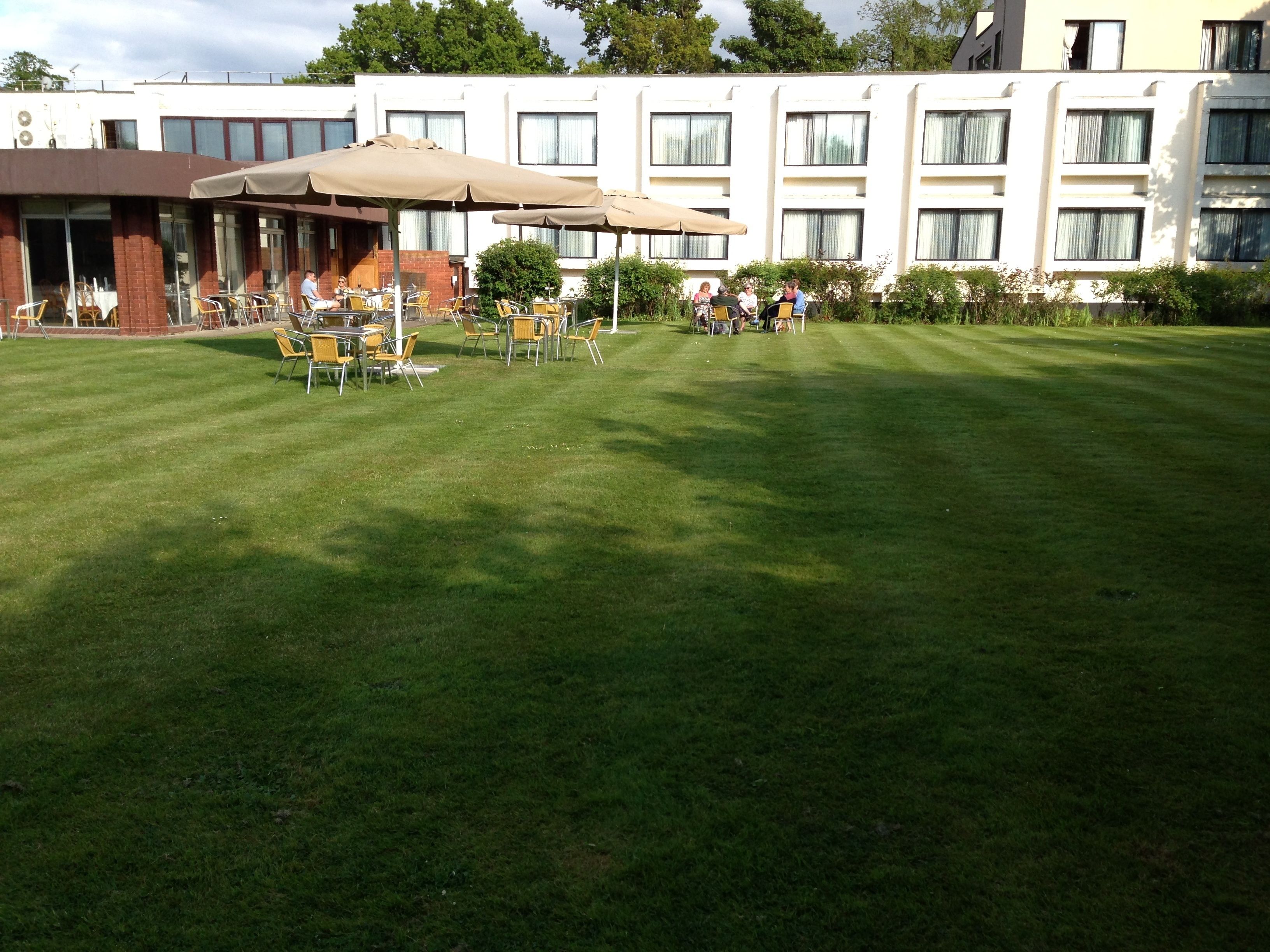 A hotel courtyard with outdoor seating and a building in the background.