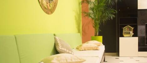 A reception area with a long bench, a potted plant, and a wall-mounted decorative piece.