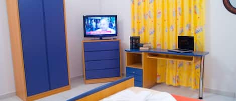 A room with a bed, a TV, a desk, and a wardrobe.