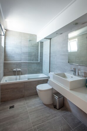 A modern bathroom with a bathtub, toilet, and sink. - Kos Bay Hotel (Kos)