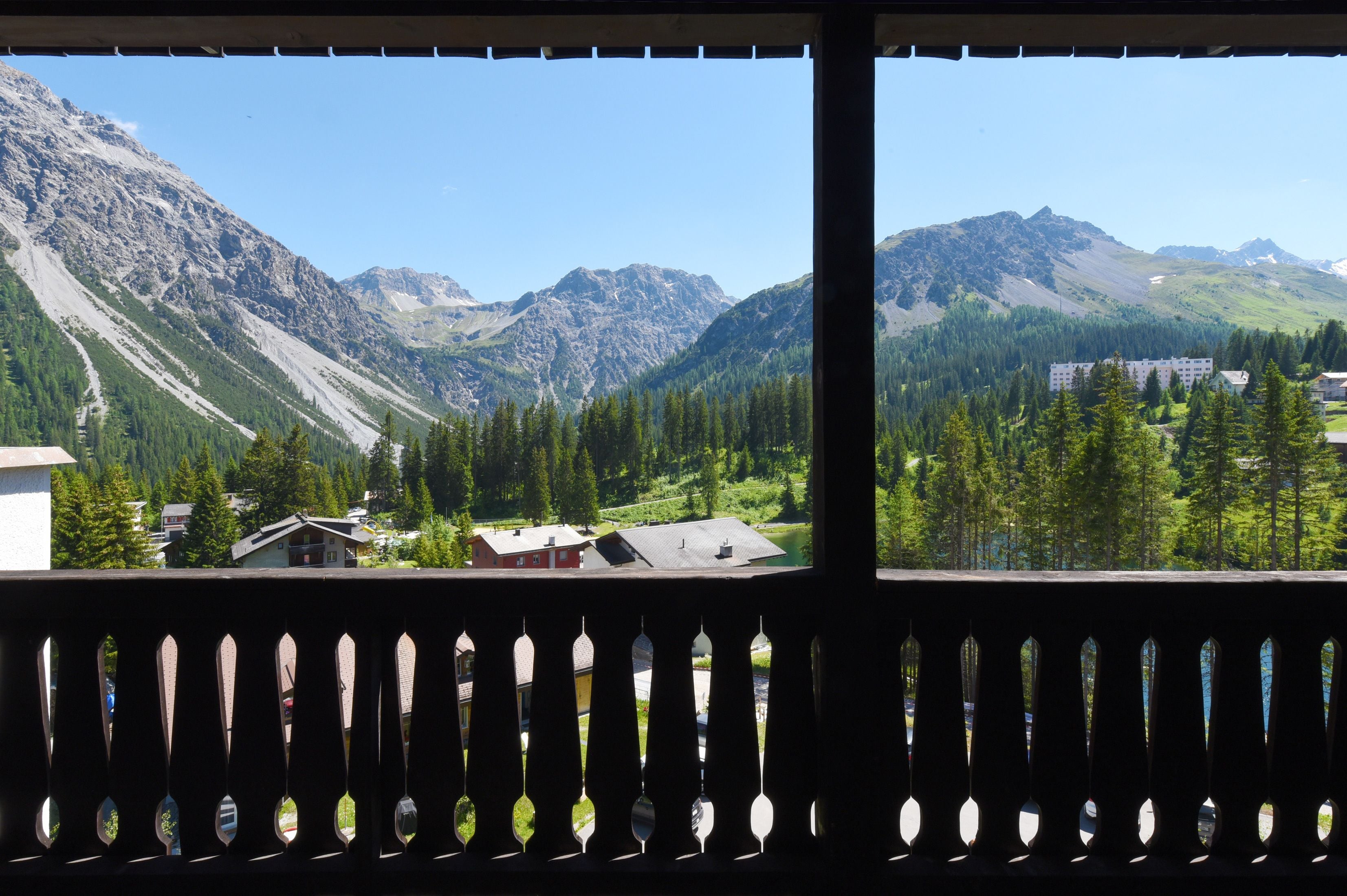 Vista de la montaña desde un balcón con barandilla.